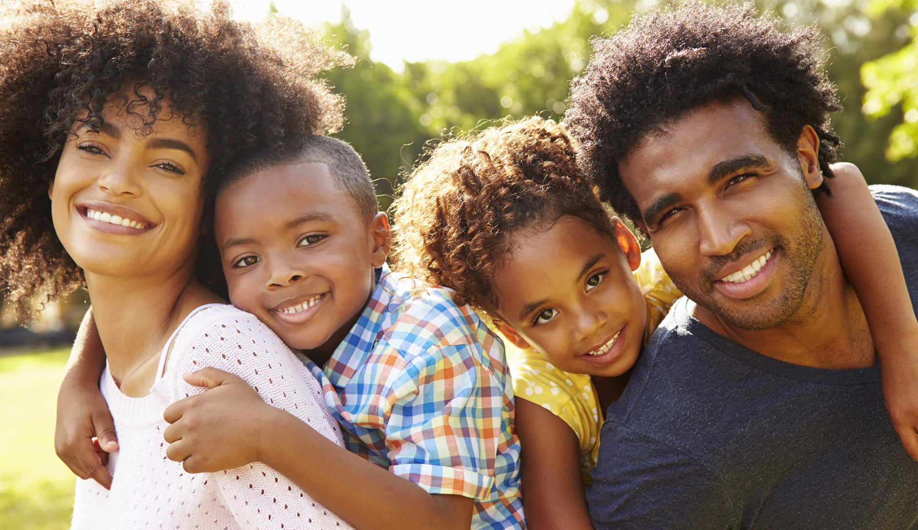 Services parents giving children piggyback ride in garden